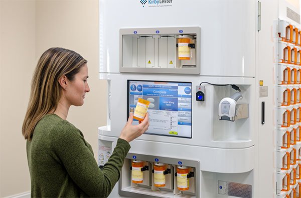 Pharmacy Technician grabbing a filled RX vial