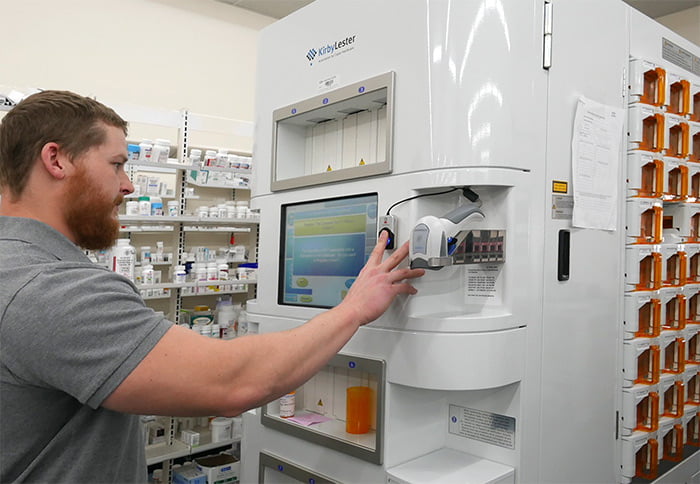 Pharmacy Technician scanning fingerprint on KL108 pharmacy automation robot