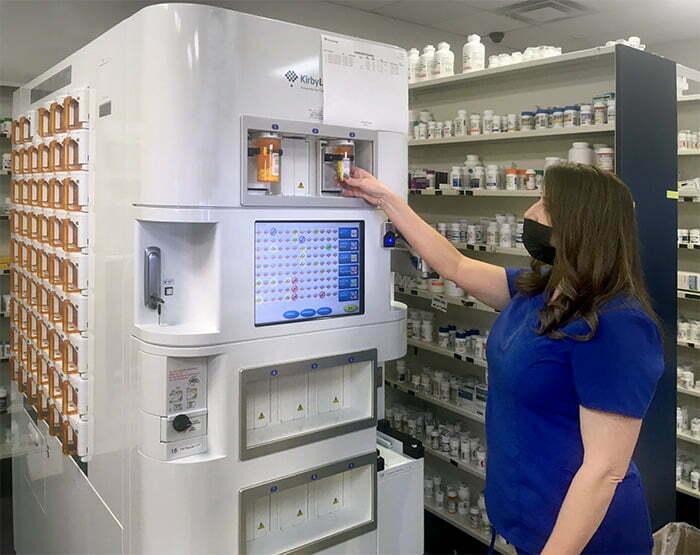 Pharmacy Technician grabbing a filled RX vial 2